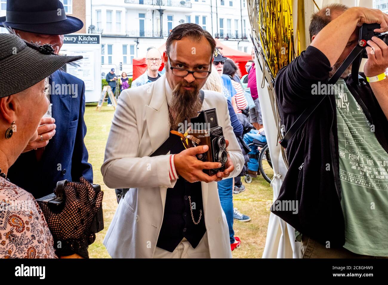 Menschen in historischen Kostümen Fotografiert mit einer altmodischen Kamera auf der Great Gatsby Fair, Bexhill on Sea, East Sussex, Großbritannien Stockfoto