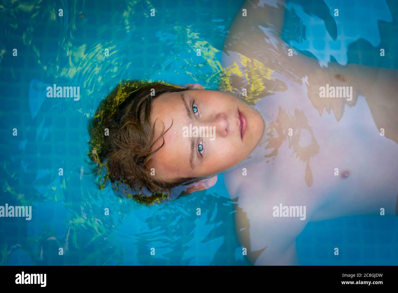 yong Mann mit erstaunlichen blauen Augen im Schwimmbad, genießen seinen Urlaub. Draufsicht Stockfoto