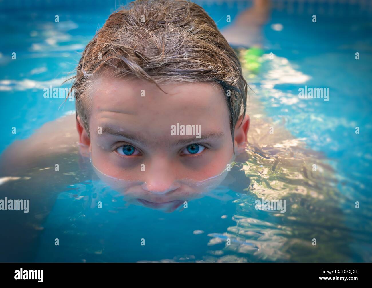 yong Mann mit erstaunlichen blauen Augen im Schwimmbad, genießen seinen Urlaub. Stockfoto
