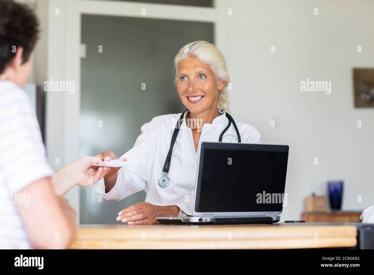 Ältere Ärztin weiblich arbeiten in einer Praxis mit Patienten Stockfoto