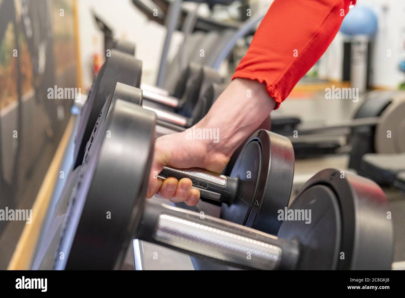 Männliche Gewichte vom Rack abheben Stockfoto