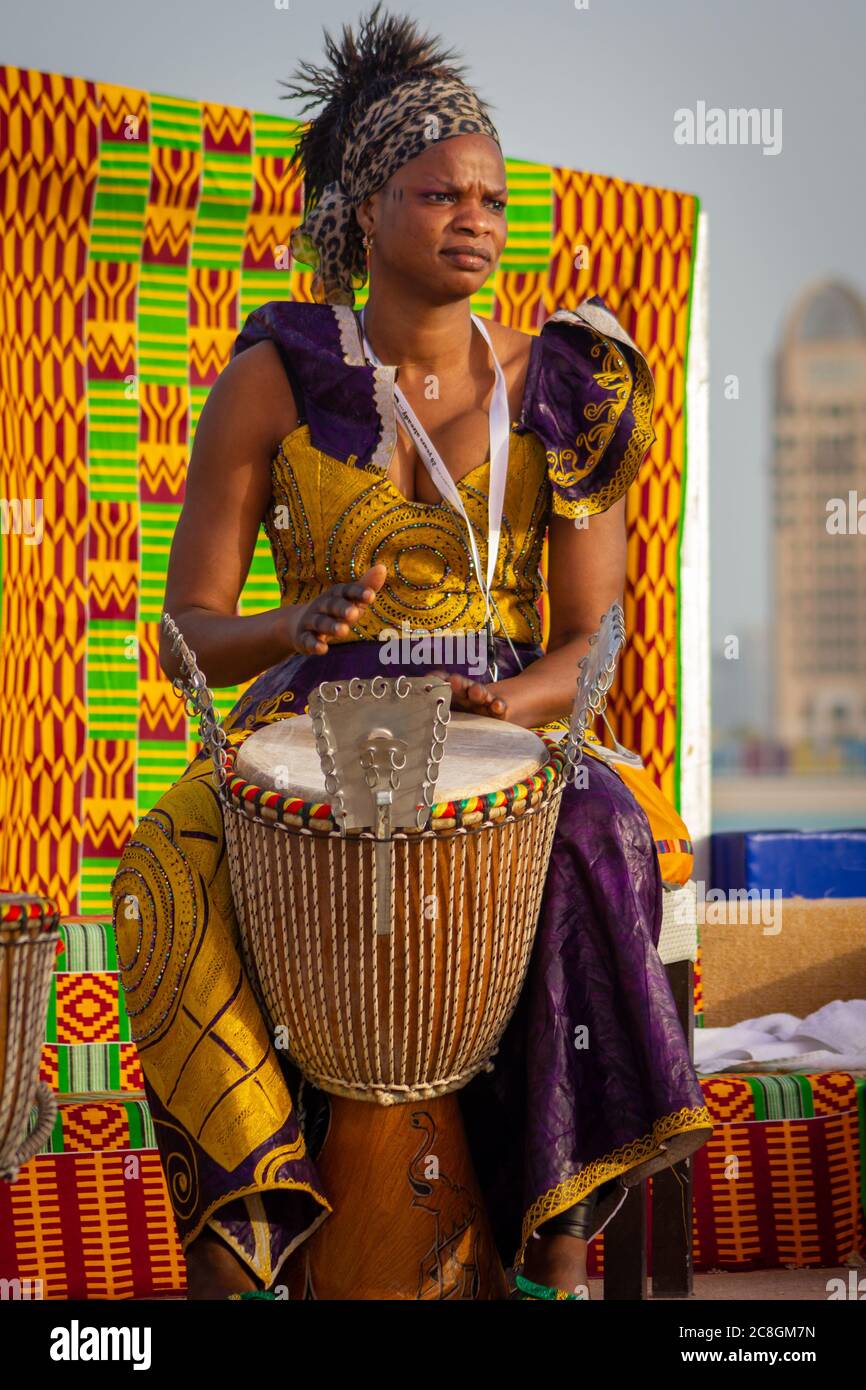 Portrait einer afrikanischen Schlagzeugin in Tracht mit unscharfem Hintergrund, aufgenommen während des afrikanischen Festivals im Katara Kulturdorf Stockfoto