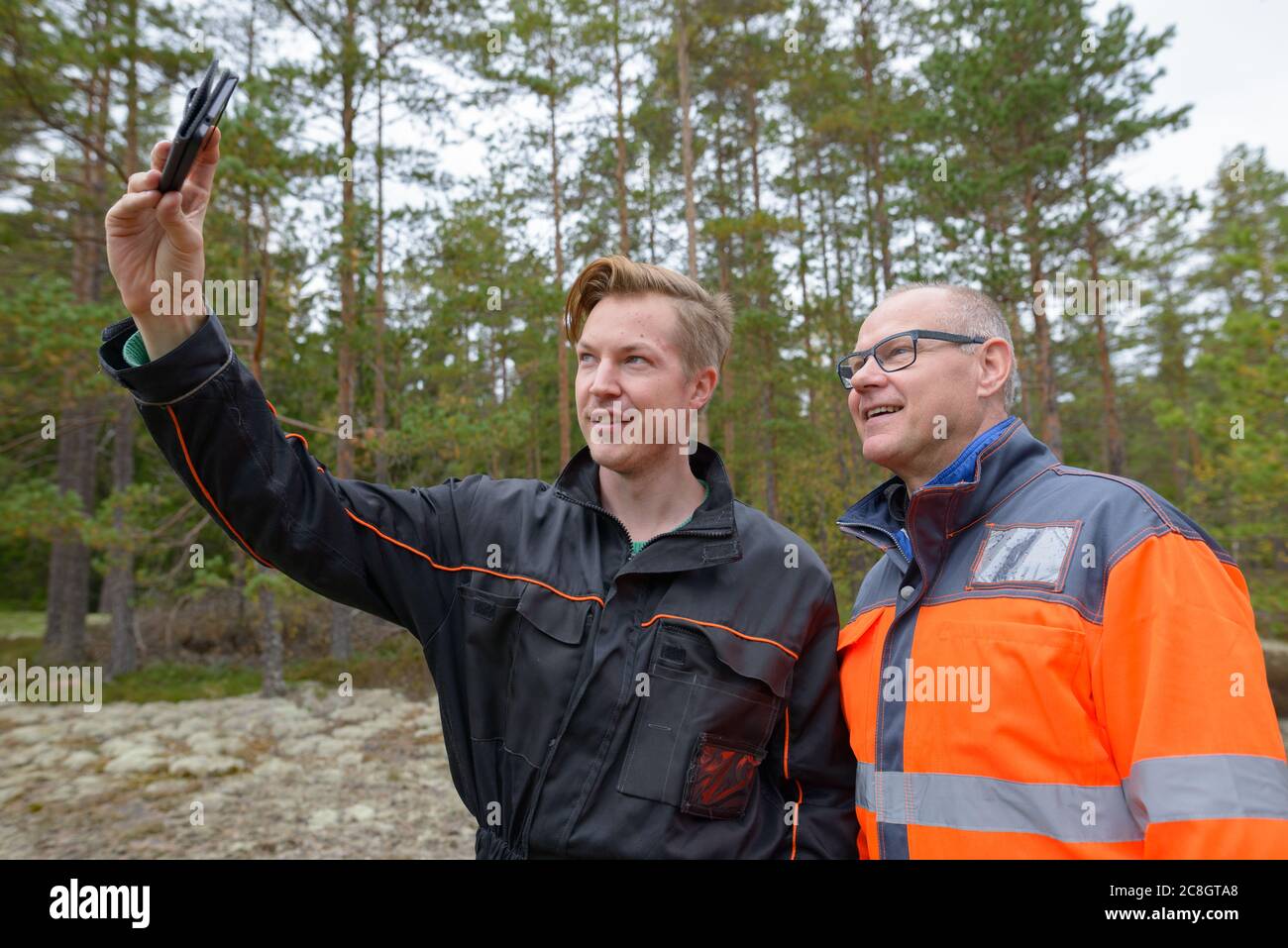 Portrait von glücklichen reifen Mann und jungen Mann zusammen Selfie im Wald Stockfoto