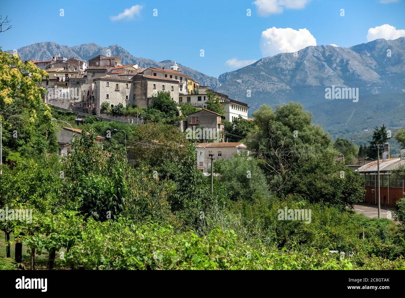 Kleine mittelalterliche italienische Stadt auf einem Hügel, mit hohen Bergen im Hintergrund, Gemeinde Pratella Stockfoto