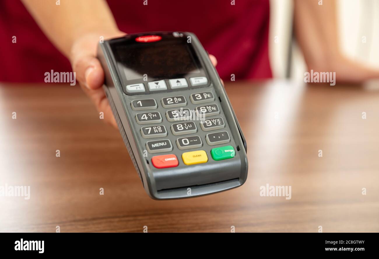 Kasse bietet POS-Terminal für die Zahlung mit Kreditkarte. Banking, Shopping und kontaktloses Bezahlen mit NFC-Technologiekonzept. Stockfoto