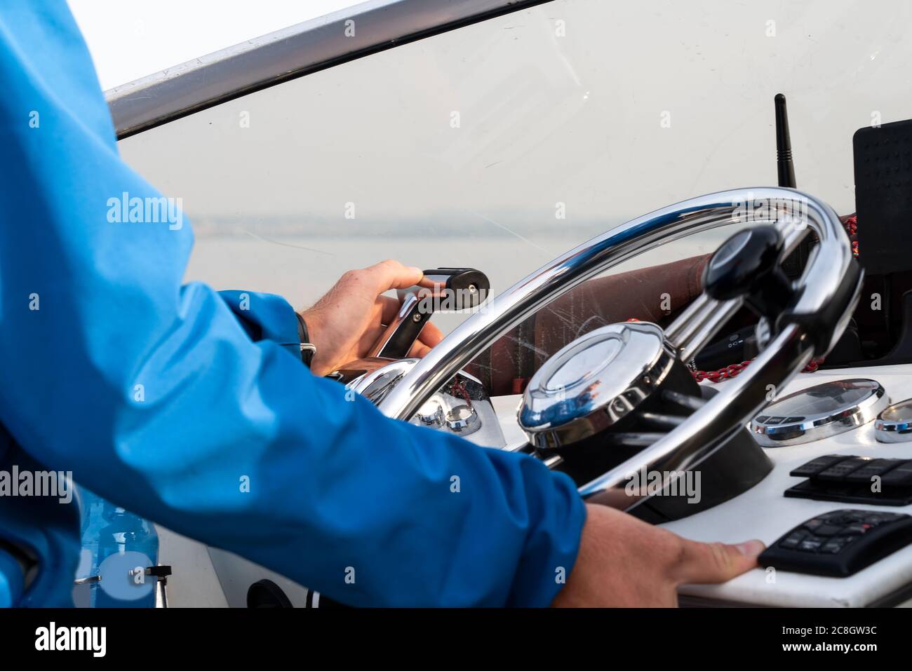 Die Hand des Mannes am Lenkrad eines Motorbootes aus nächster Nähe Stockfoto