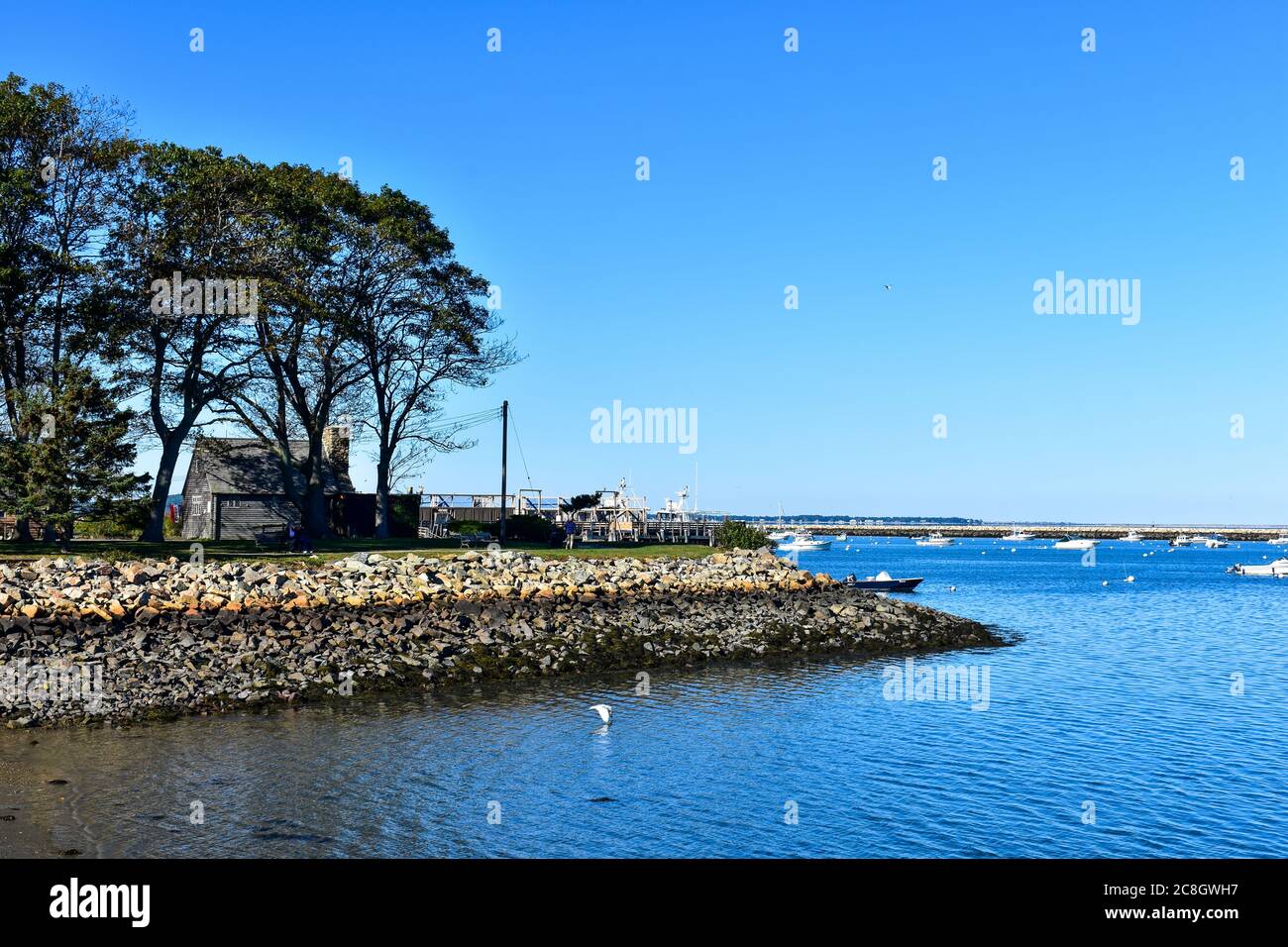 Plymouth, MA Hafen mit Steinmauer, Dock und Reproduktion Kolonialhaus mit Steinsteg im Hintergrund Stockfoto