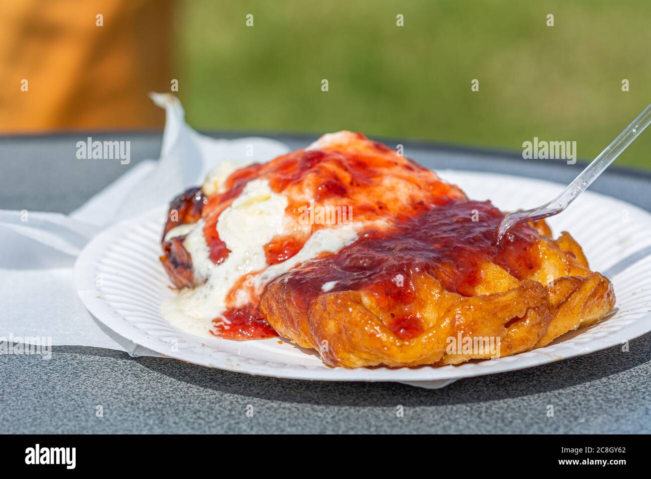 Nahaufnahme von belgischen Waffeln mit Marmelade und Sahne auf einem Pappteller Stockfoto