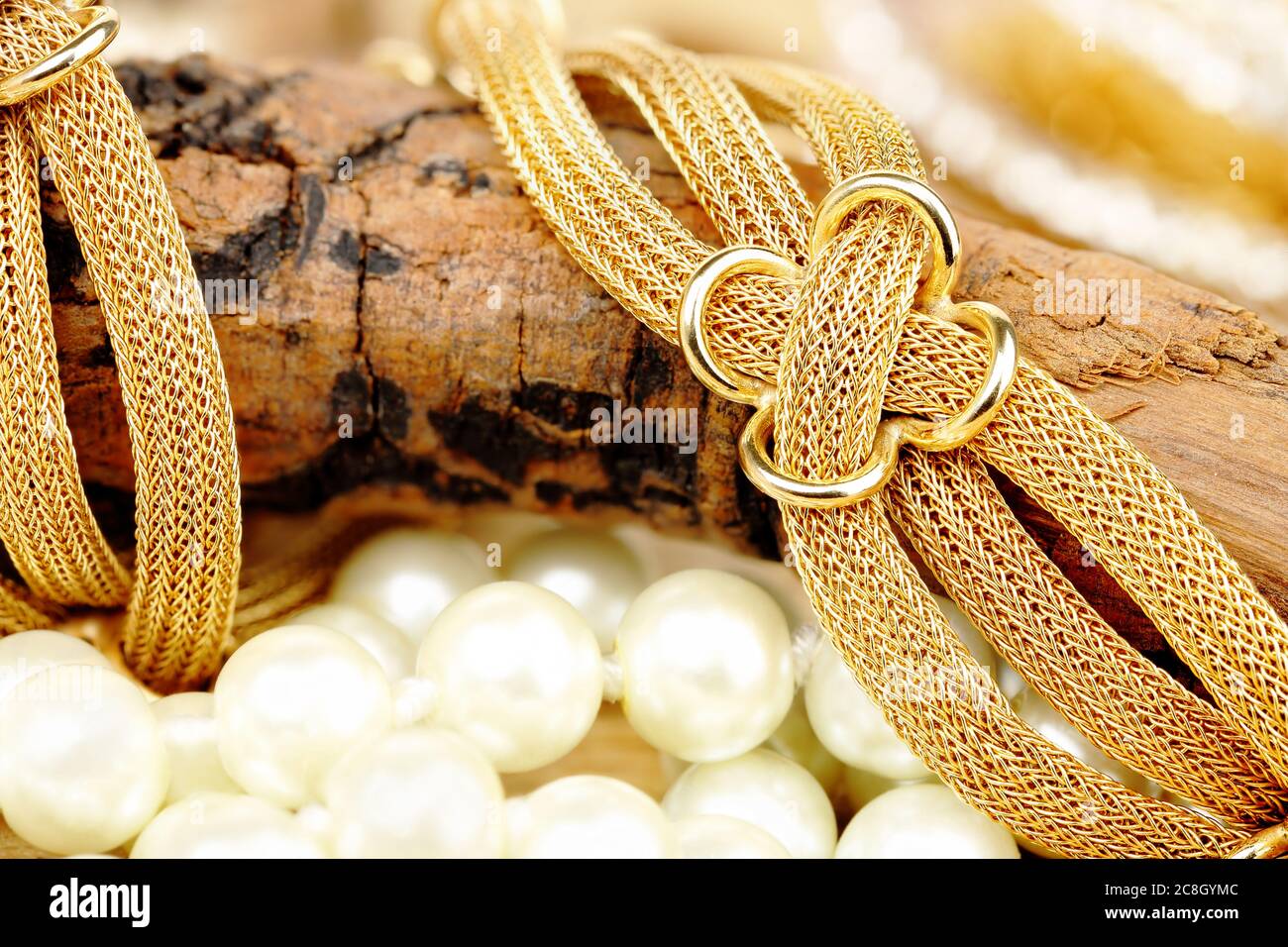 Nahaufnahme von goldenem Armband auf verwittertem Stück Holz Stockfoto
