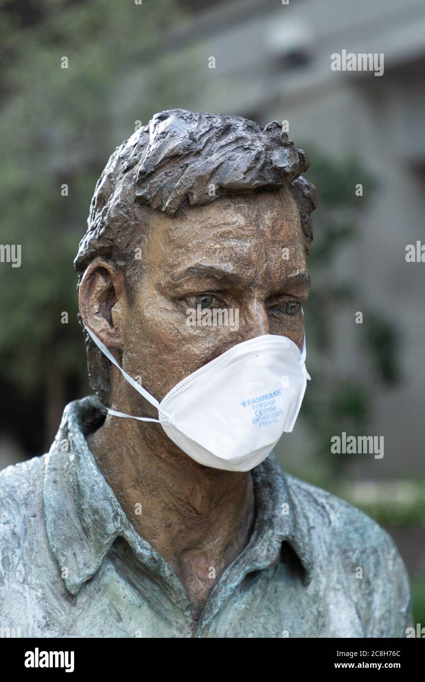 Eine Gesichtsmaske, die an einer öffentlichen Skulptur während der COVID-19 Pandemie angebracht ist, Paddington, London, 22. Juli 2020 Stockfoto