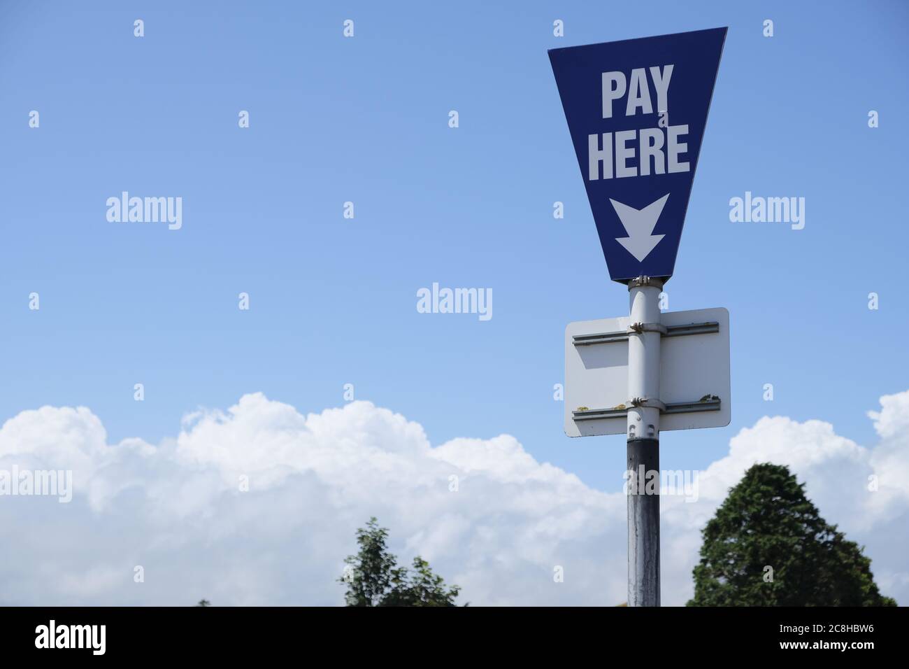 Ein blaues Straßenschild weist auf die Lage einer Zahlstelle auf einem Parkplatz in England hin Stockfoto