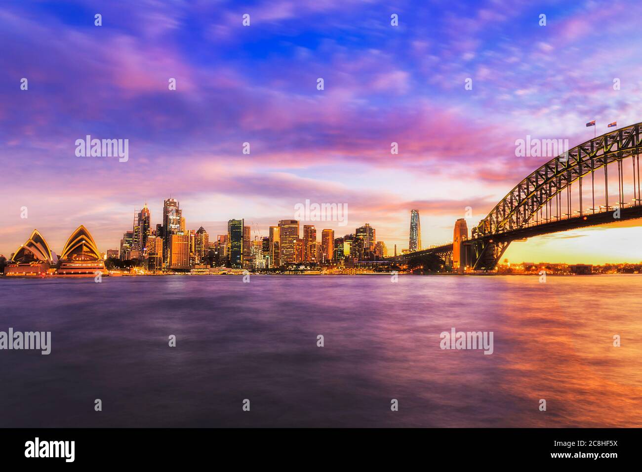 Farbenfrohe Sonnenuntergänge in der Stadt Sydney rund um den Hafen und die Wahrzeichen des Geschäftsviertels. Stockfoto