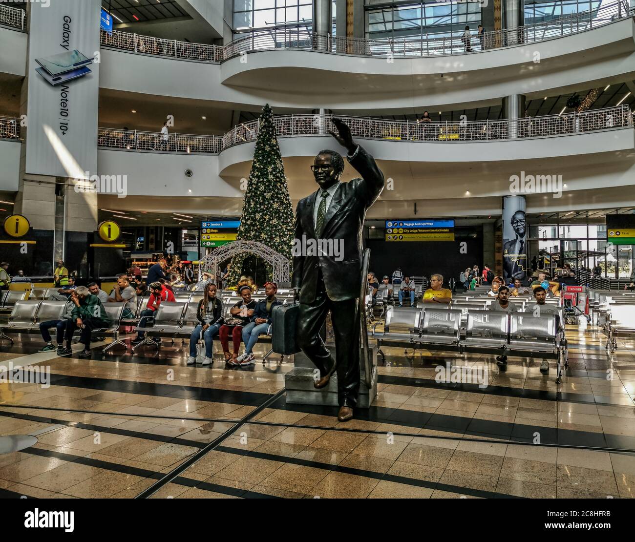 Johannesburg, Südafrika - 25. Januar 2020: Menschen, die im Arival-Terminal am internationalen Flughafen O R Tambo mit Oliver Tambos Statue in Johannes warten Stockfoto