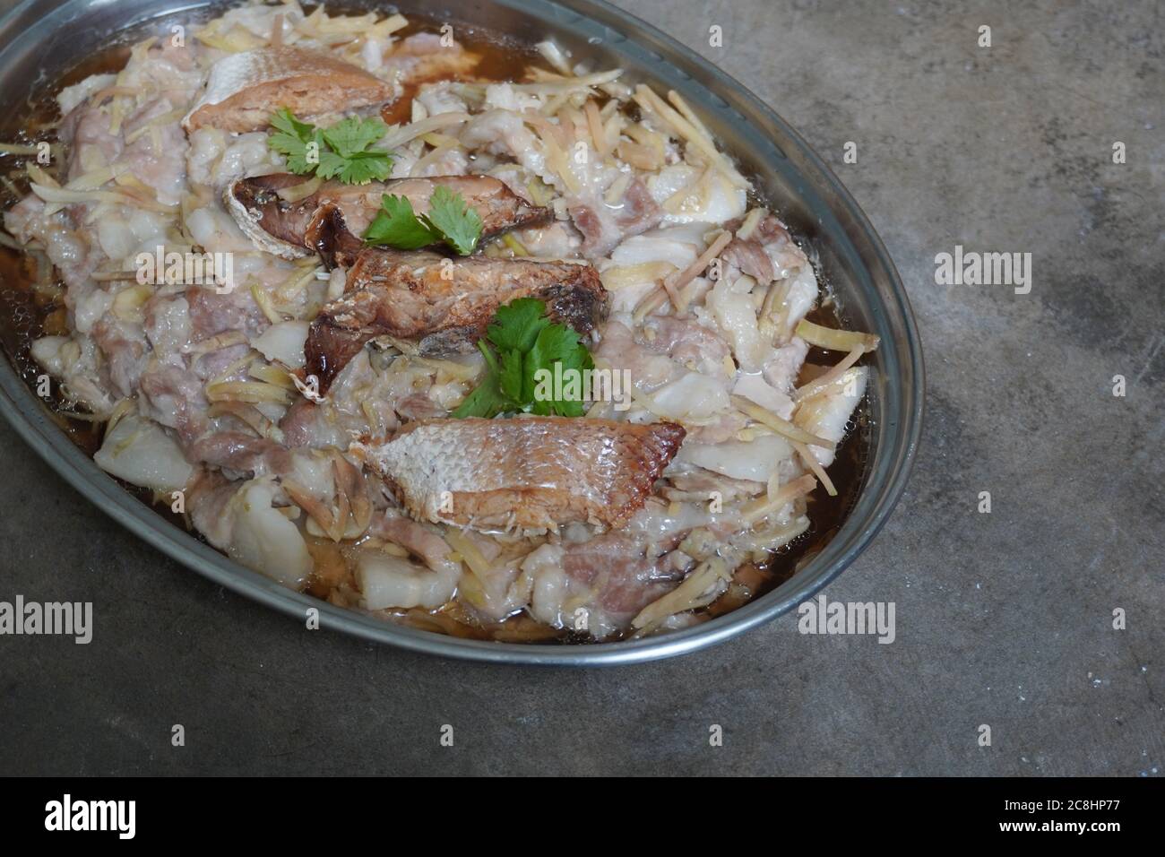 Traditionelle gedünstete Schweinefleischscheiben mit gesalzenem Fisch. Stockfoto