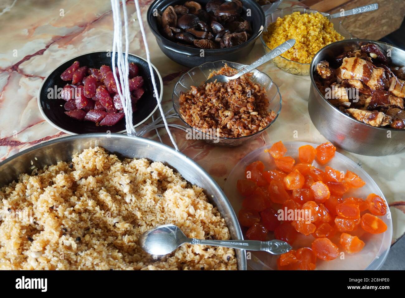 Zongzi oder Reisknödel ist klebrigem Reis mit süßen oder herzhaften Füllungen in Bambus oder Schilfblättern eingewickelt. Frische Zutaten für die Zubereitung. Stockfoto