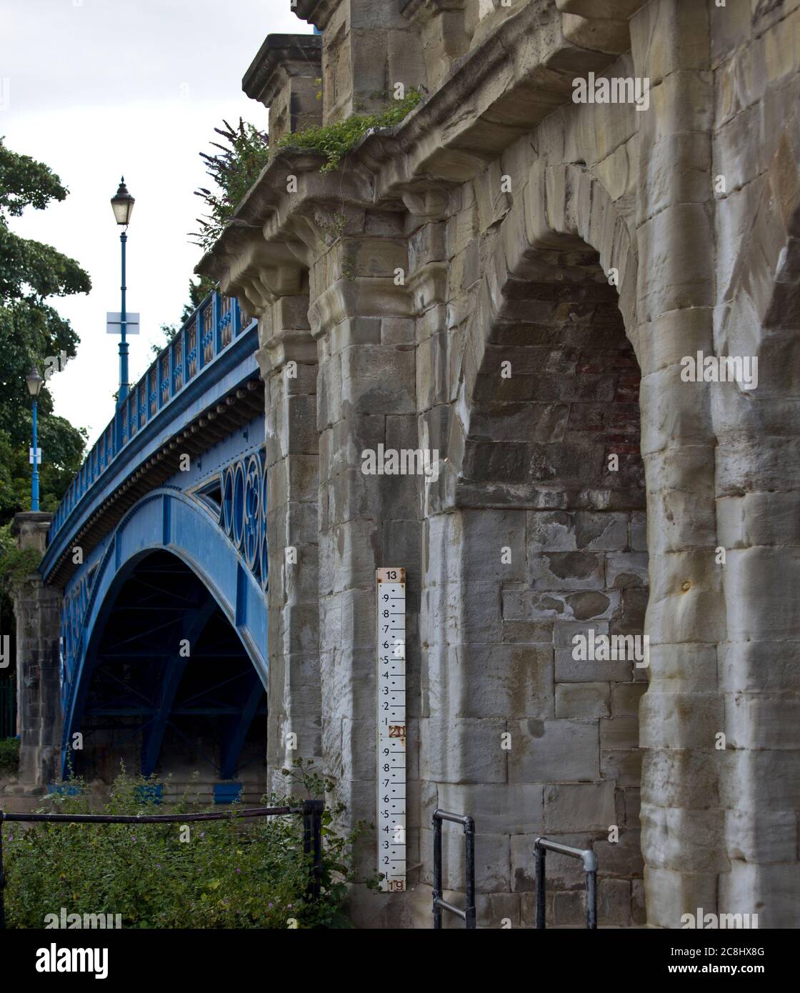 Hochwassersäule entlang eines Flusses, unter einer Brücke, in einem Dorf, Hochwasser, Wetter, Hochwasseranzeige, Hochwasserlineal, Aufzeichnungen, Hochwasserwarnmeldungen, Vorbereitung Stockfoto