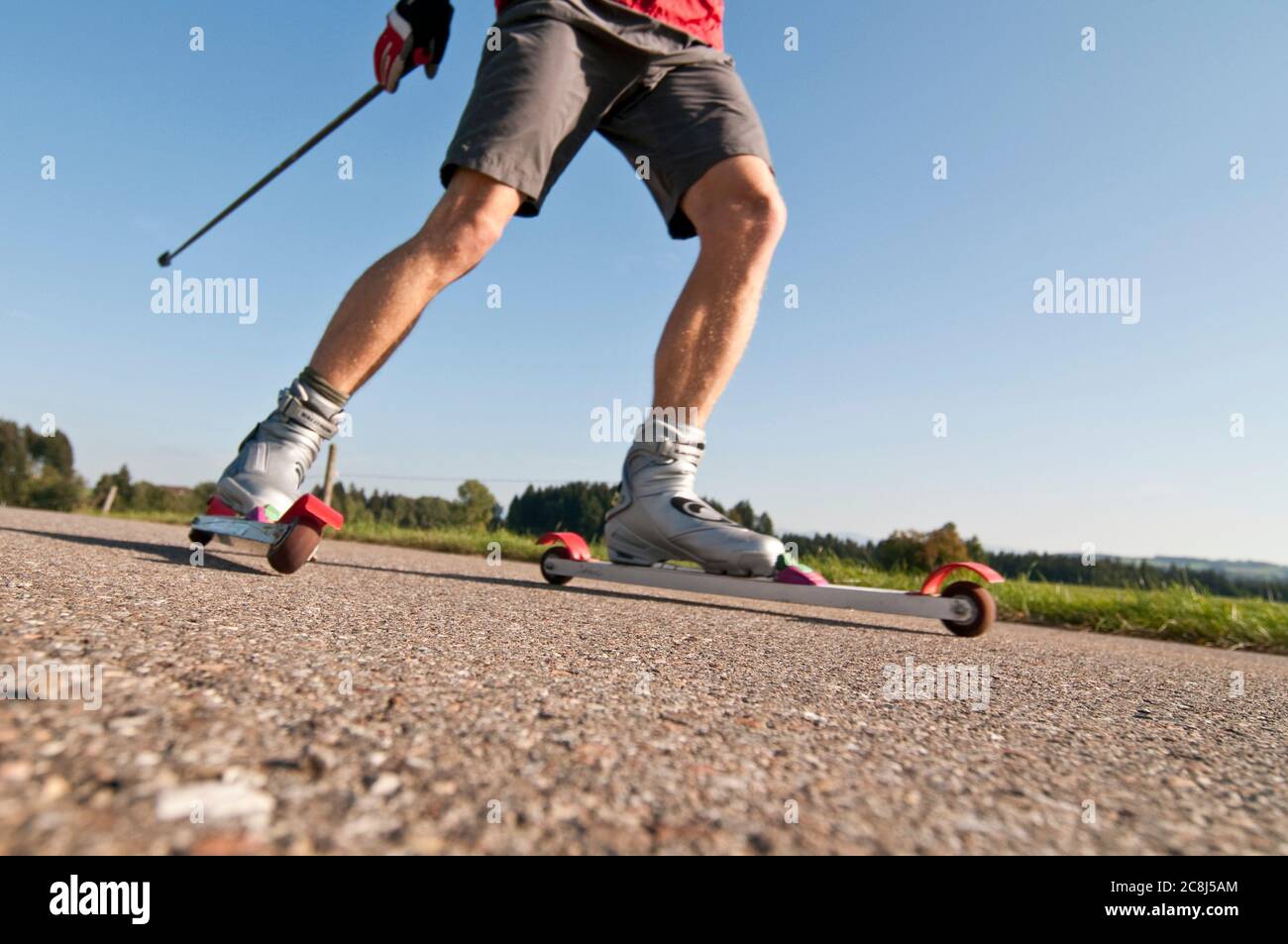 Junger Mann, der im Sommer eine Trainingseinheit auf Skirollen macht Stockfoto