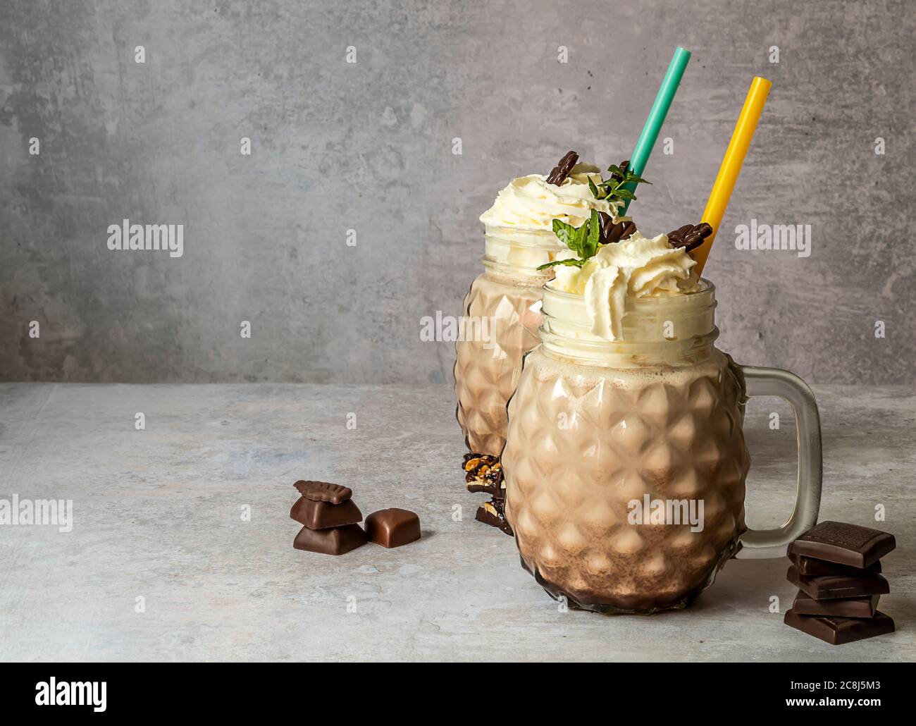 Süßer Schokoladenmilchshake mit Eis, Kaffee und Schlagsahne in einem Glas-Einmachglas. Stockfoto