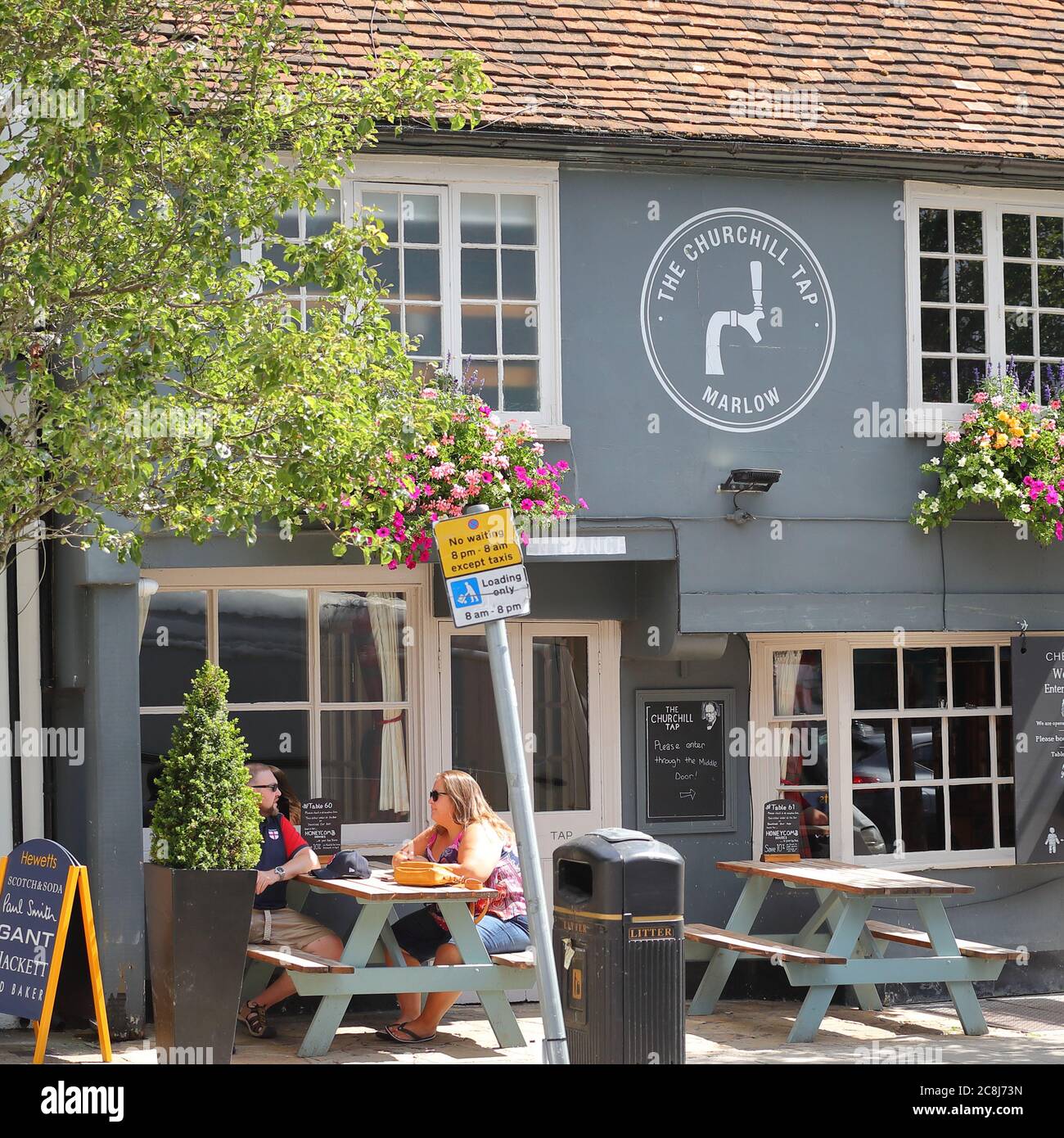 Menschen, die das Wetter außerhalb der Churchill Tap in Marlow, Großbritannien, genießen Stockfoto