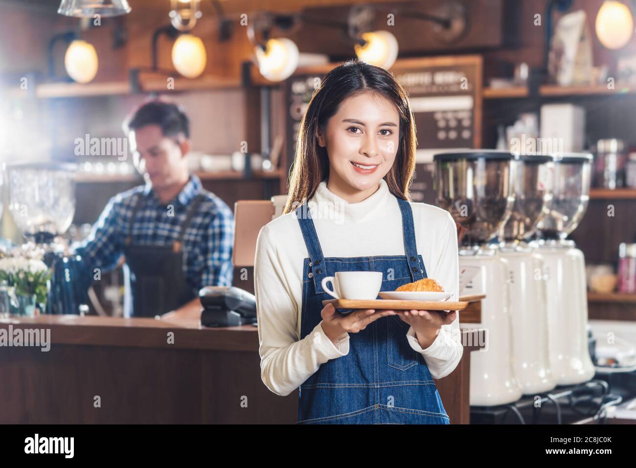 Asian Coffee Shop Besitzer Serving Backwaren Kuchen und Kaffeetasse an Kunden in Coffee Shop, Kleinunternehmen Eigentümer und Startup in Coffee Shop und Restaurant, Stockfoto