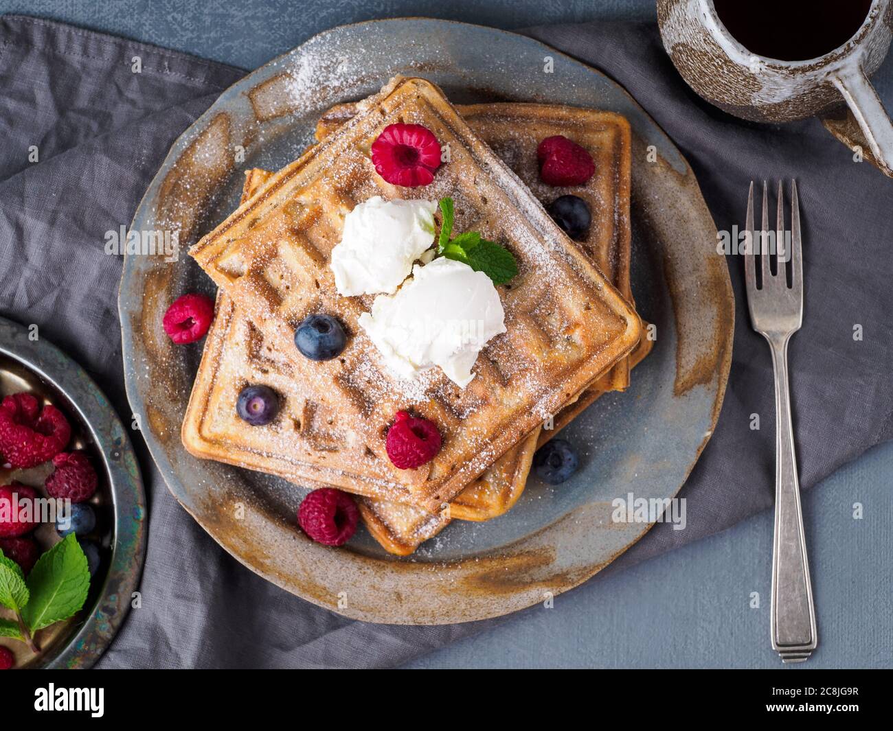 Belgische Waffeln mit Himbeeren, Schokoladensirup. Frühstück mit Tee Stockfoto