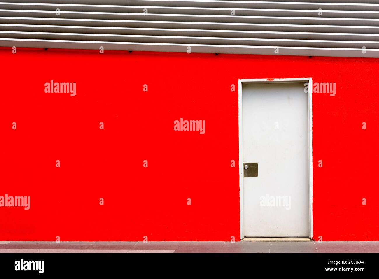 Geschlossene Tür auf rotem Wandhintergrund in Kuala Lumpur mit Copyspace Stockfoto