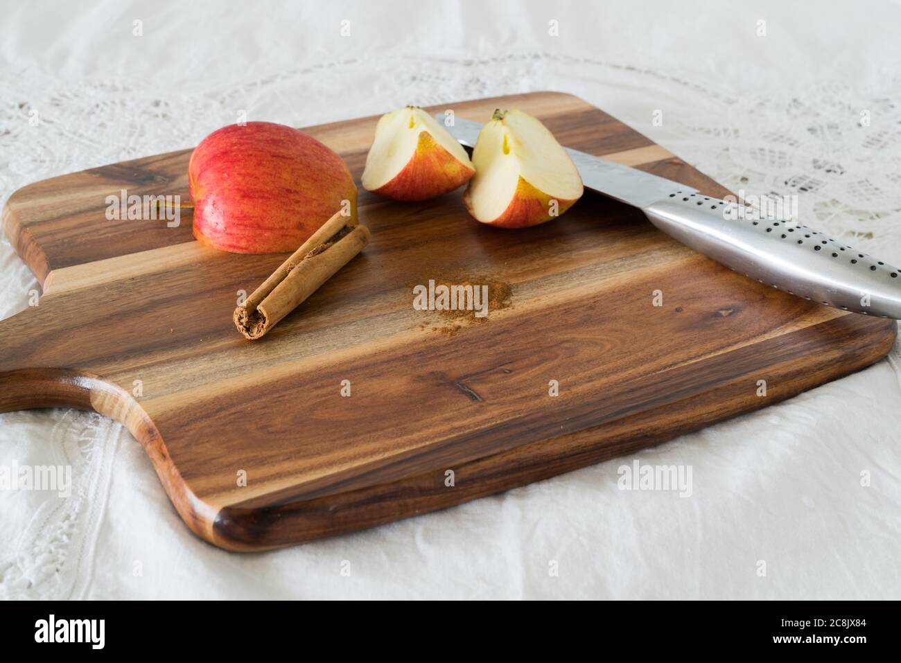 Apfelkeile mit Zimtstange und gemahlenem Zimt auf Holzbrett Stockfoto