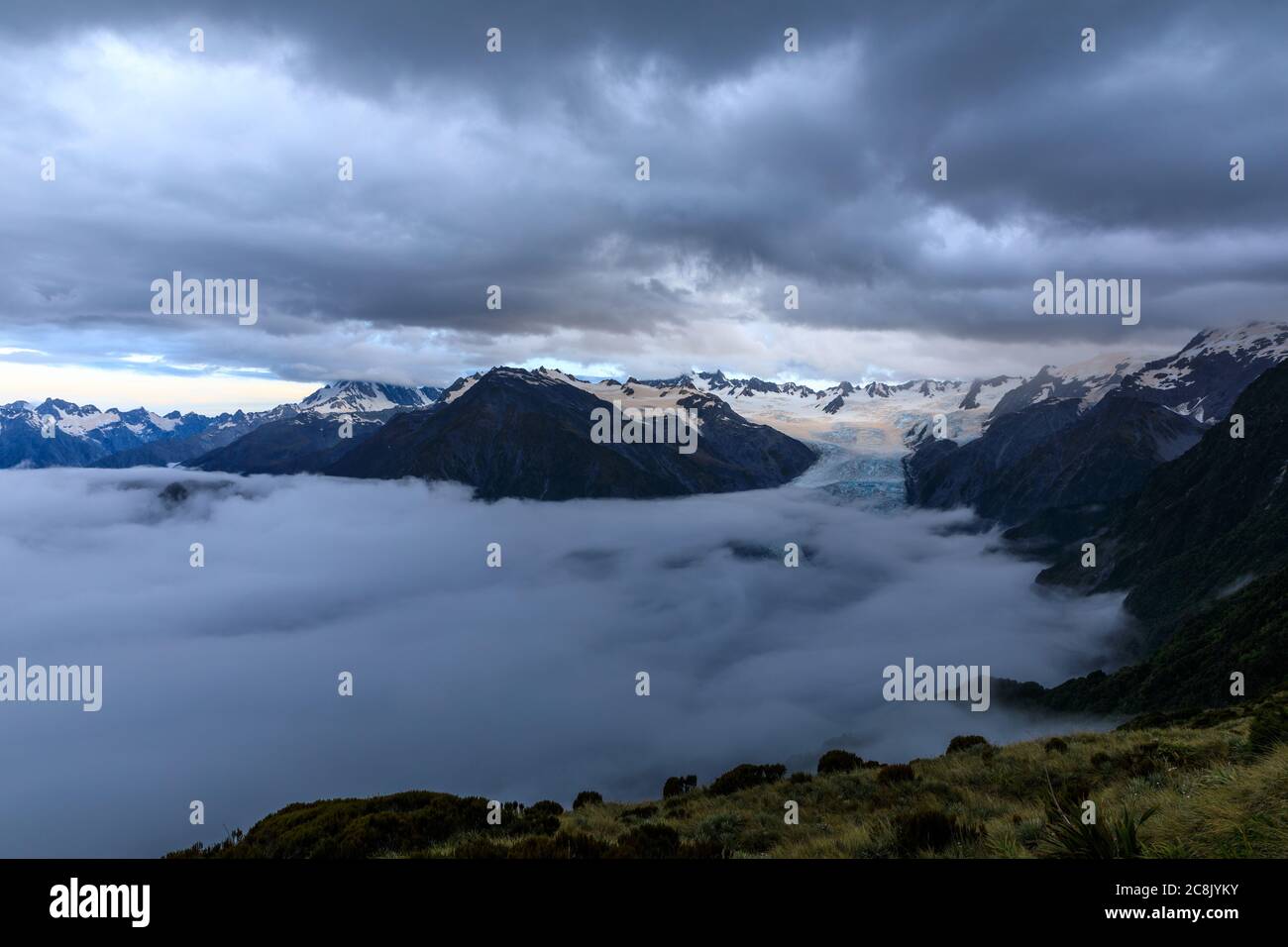 Wolkeninversion über dem Franz-Josef-Tal mit einem Großteil des Franz-Josef-Gletschers, der nach Sonnenuntergang von den Wolken verdeckt wird, Blick von Alex Knob. Stockfoto