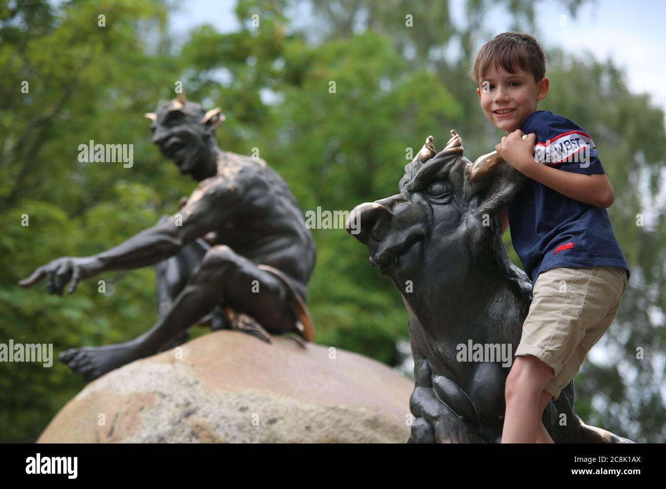 Thale, Deutschland. Juli 2020. Ein Kind klettert auf eine mythische Figur auf der Hexentanzfläche. Die Hexentanzfläche ist ein beliebtes Ausflugsziel. Quelle: Matthias Bein/dpa-Zentralbild/dpa/Alamy Live News Stockfoto