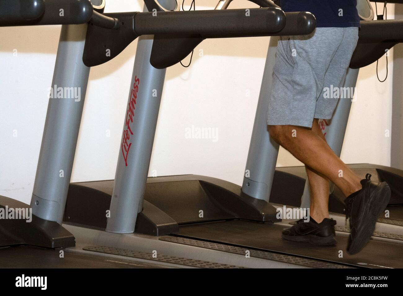 Mans Beine auf Laufband im Fitnessstudio Stockfoto