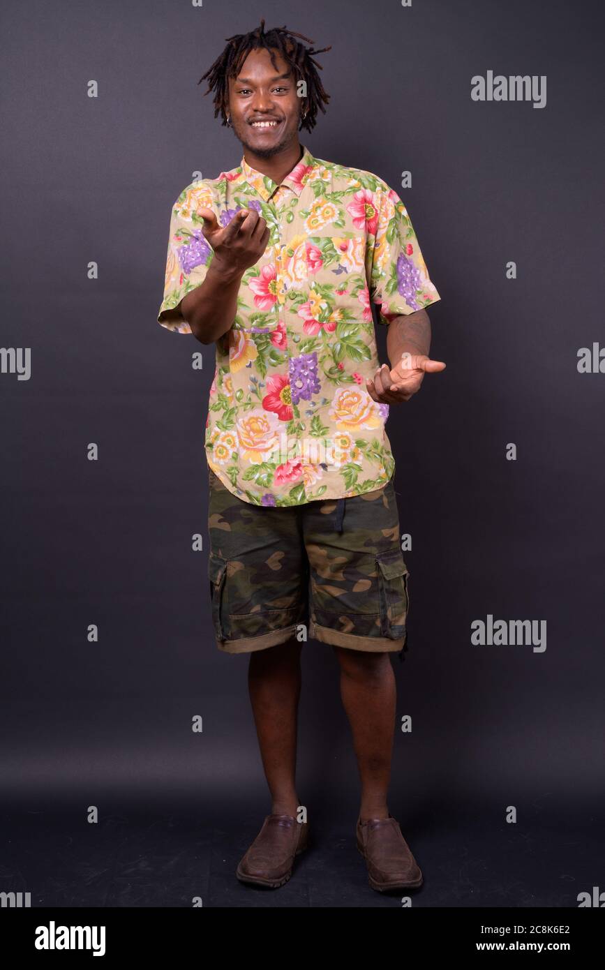 Junger Afrikaner mit Dreadlocks vor schwarzem Hintergrund Stockfoto