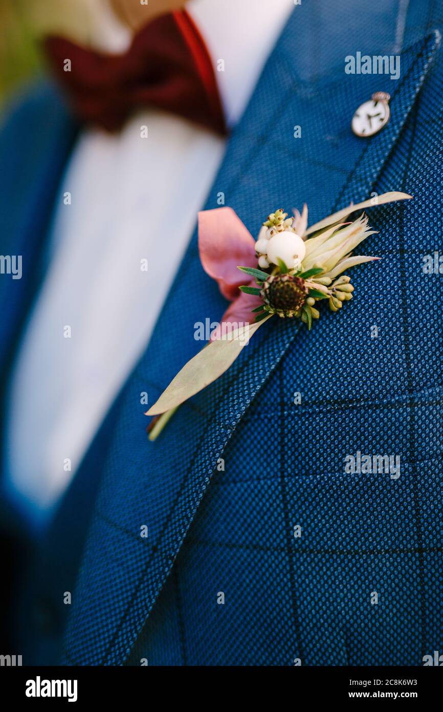 Der Budier des Bräutigams aus gelben Blumen auf einer karierten Jacke und einer roten Fliege. Stockfoto