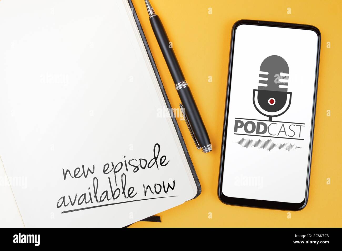 Podcasting Konzept, Text NEUE EPISODE JETZT VERFÜGBAR geschrieben auf Notizblock und Smartphone mit Podcast-Player Mockup auf orangenen Schreibtisch Stockfoto