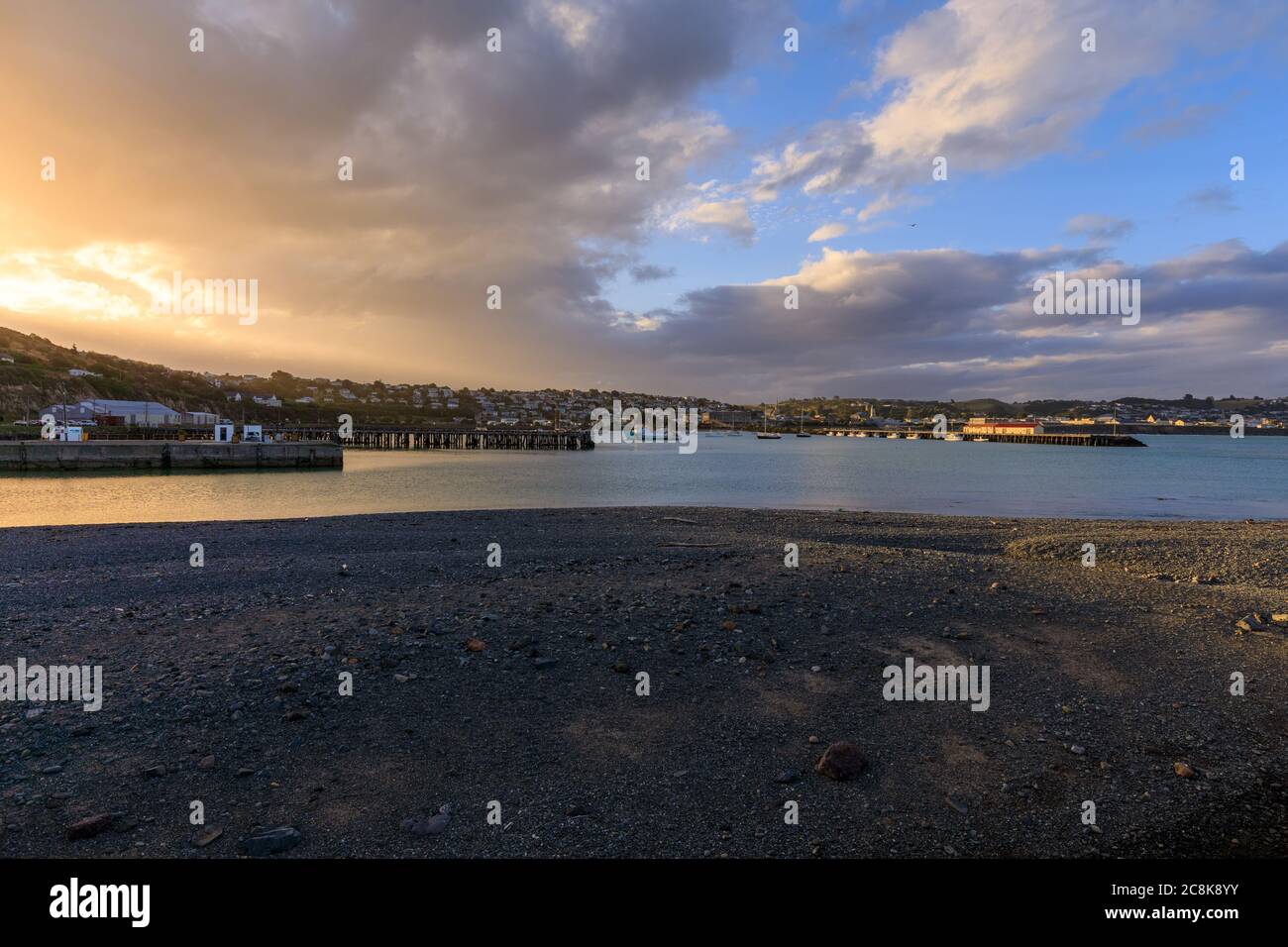 Oamaru Hafen bei Sonnenuntergang mit dem Oamaru im Hintergrund. Stockfoto