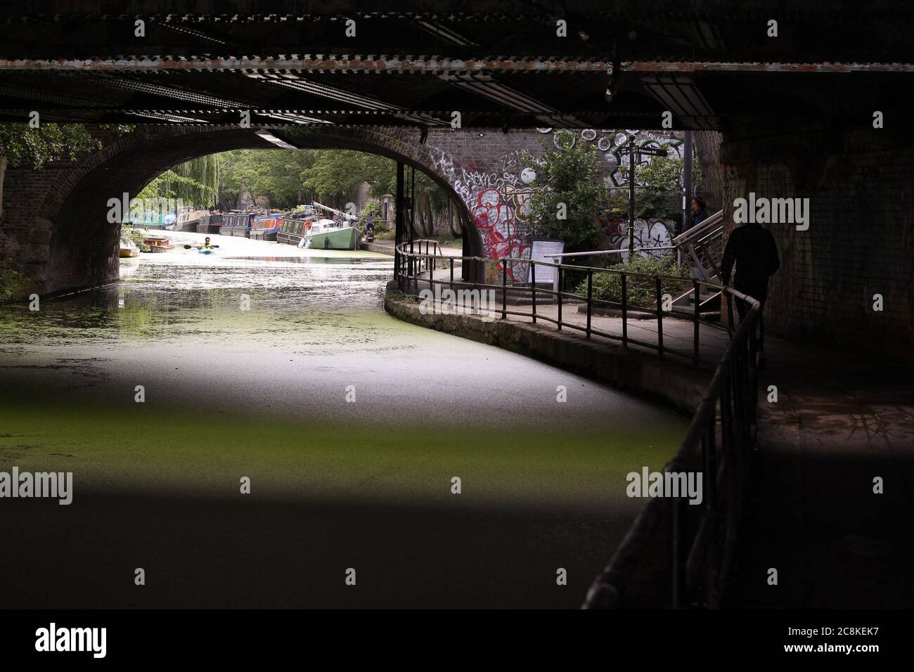 London, England. Vereinigtes Königreich. August 2019. Ein Spaziergang über den Regent's Canal mit Brücken, Booten und grünem Wasser in der Nähe von Camden Town Stockfoto