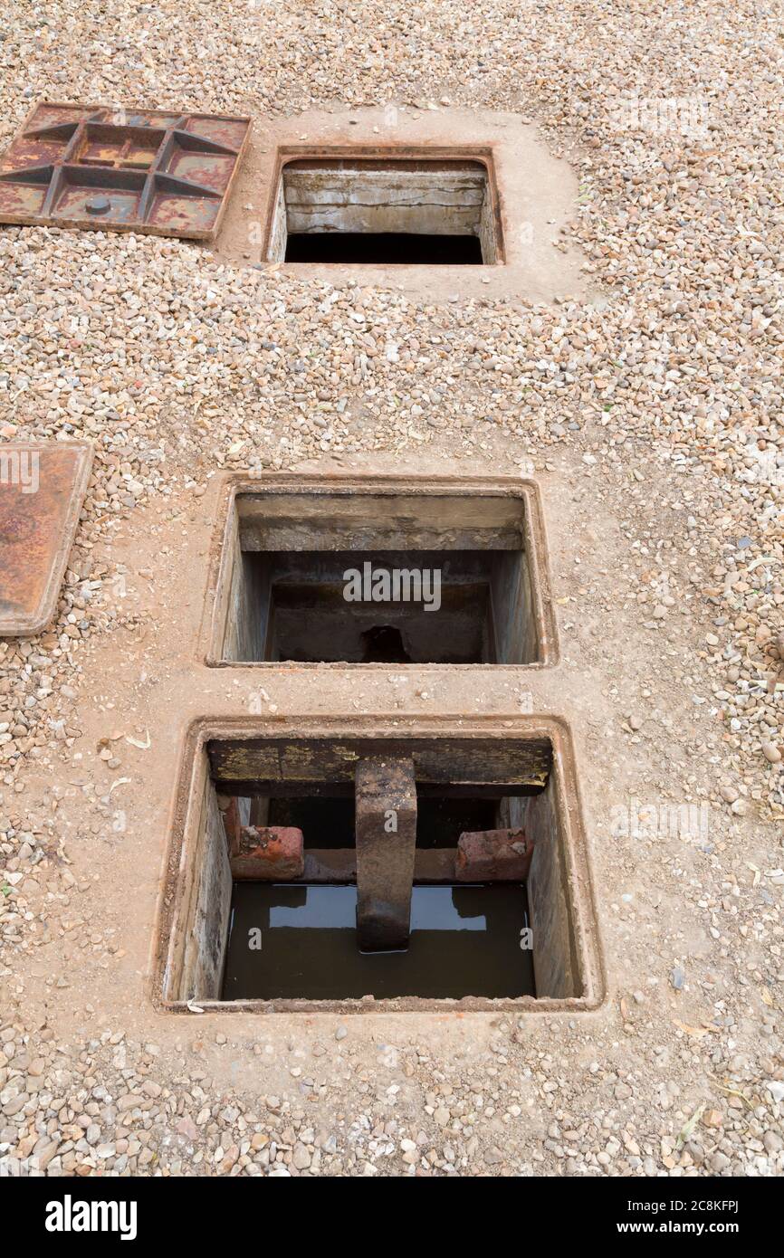 Inspektion eines unterirdischen Klärgrubs oder Regenwasserentnahmebehälters mit offener Inspektionskammer, Großbritannien Stockfoto