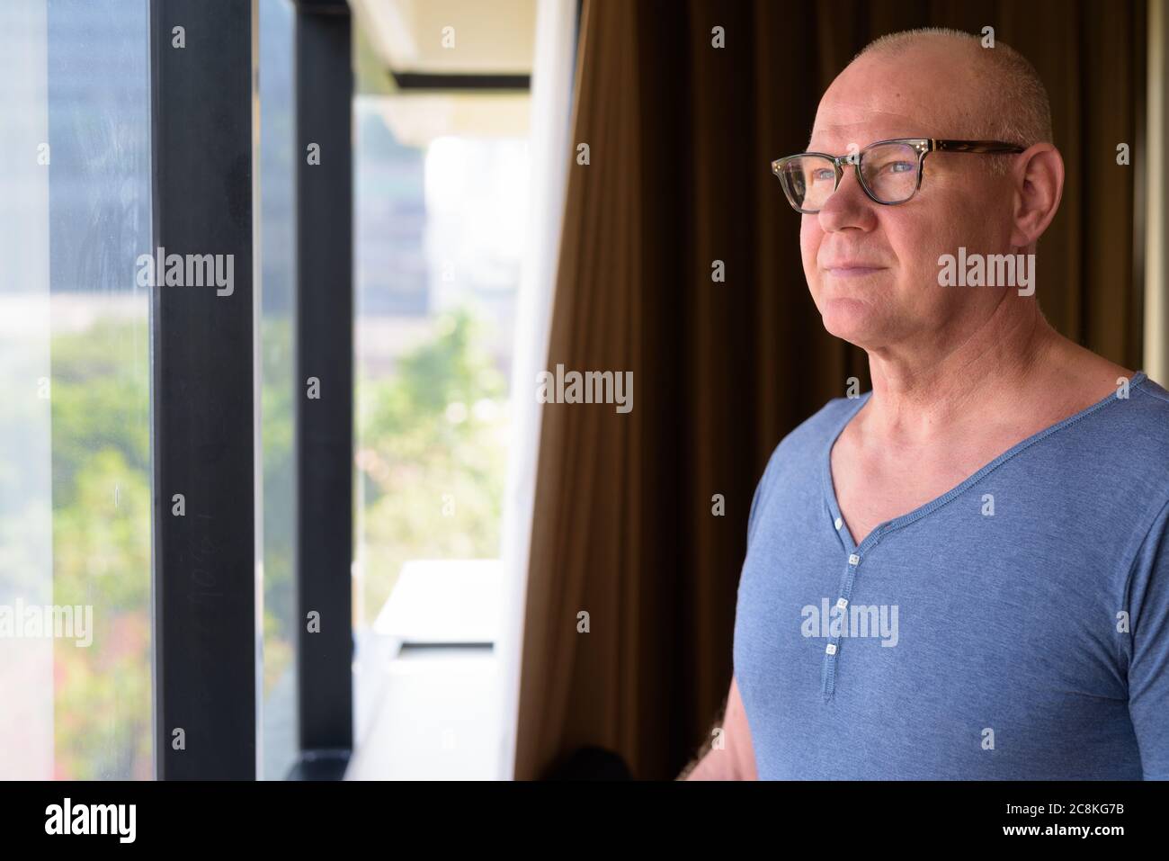 Ein älterer, hübscher skandinavischer Mann im Zimmer am Fenster Stockfoto