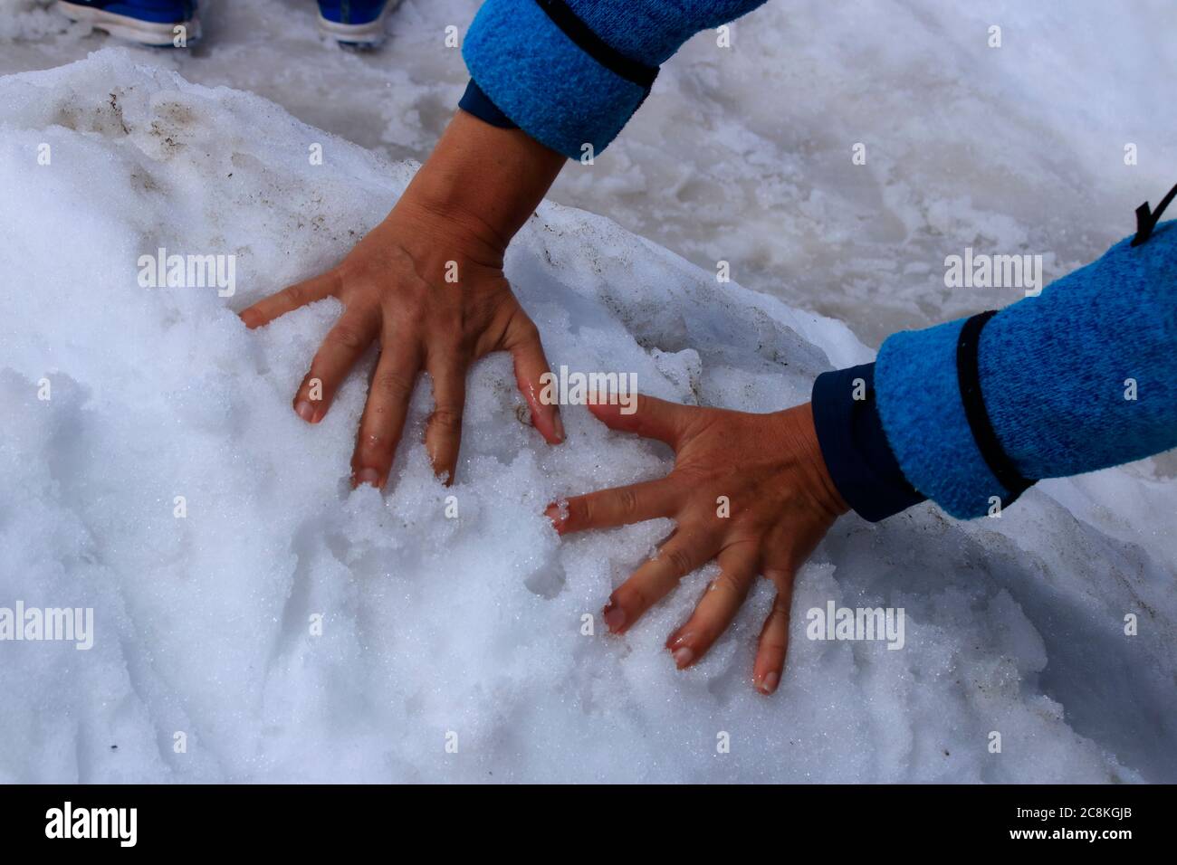 2 Hände greifen in einen Schneehaufen Stockfoto