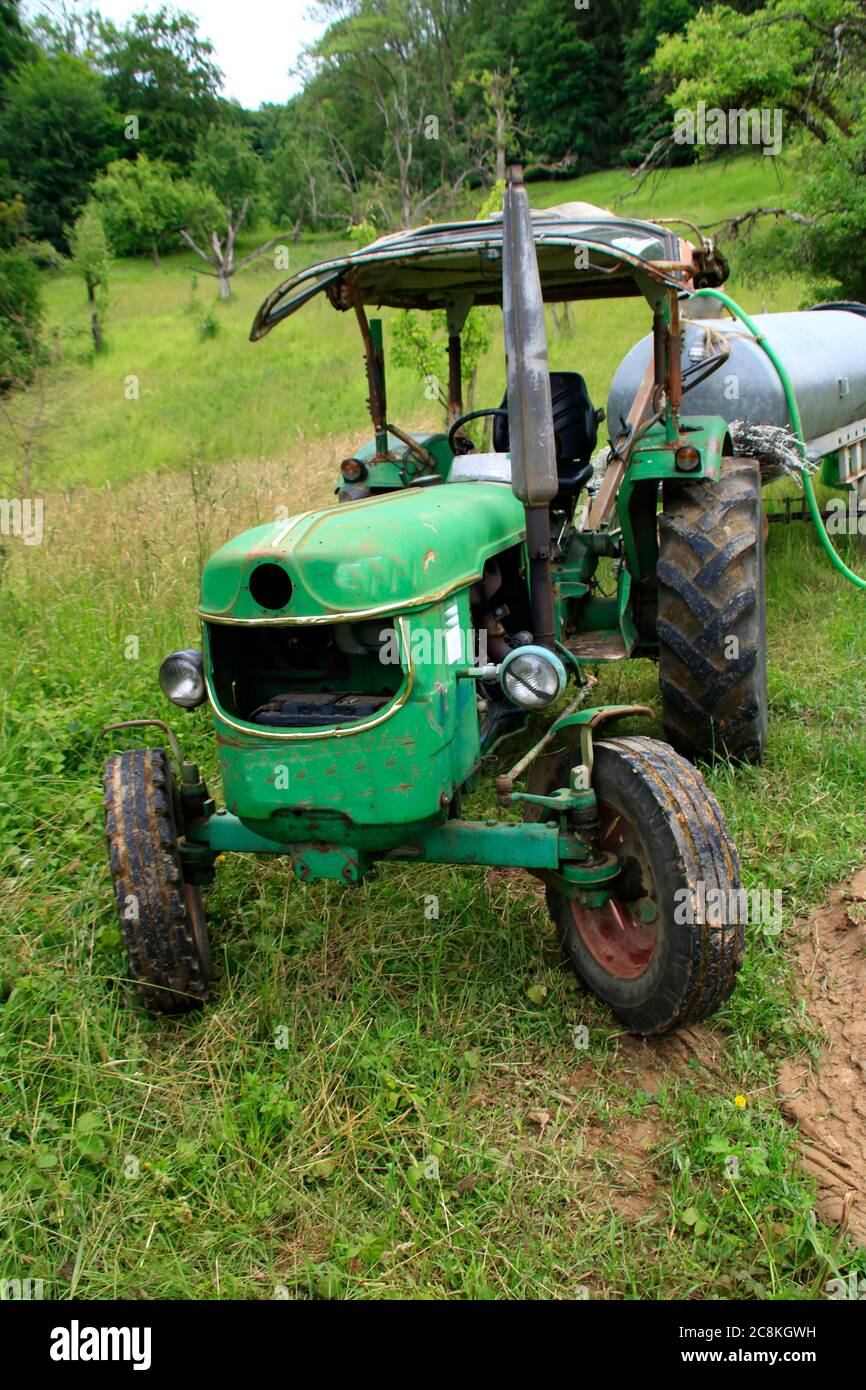 Alter Traktor mit Wassertank auf einer Wiese Stockfotografie - Alamy