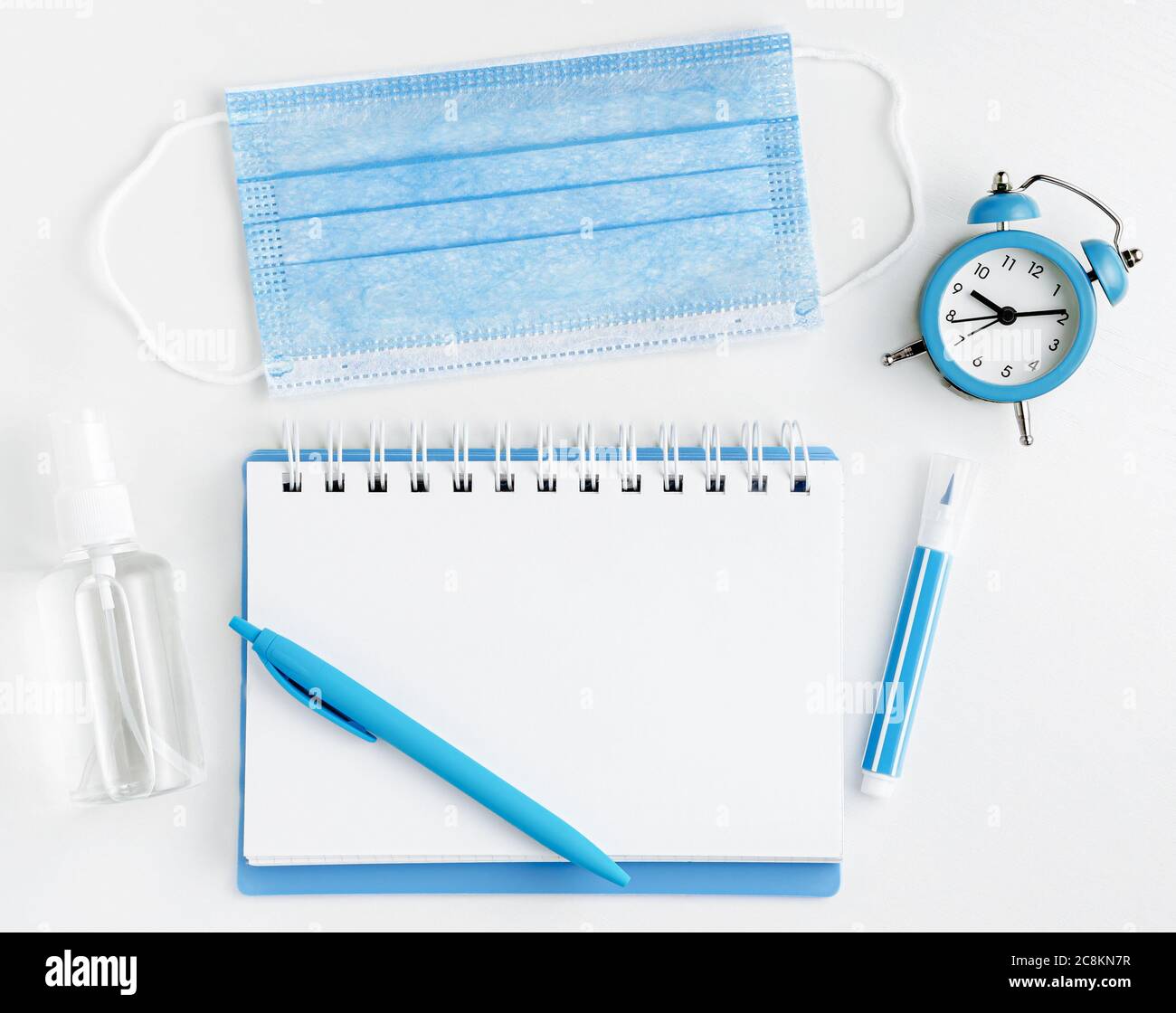Home Schulkonzept. Notebook blank, Maske und Desinfektionsflasche auf weißem Hintergrund. Draufsicht Stockfoto