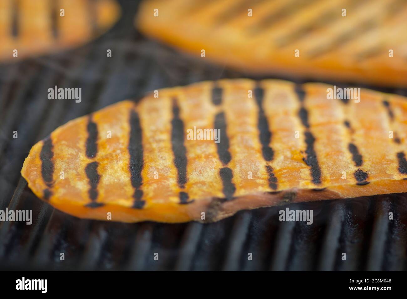Scheiben Süßkartoffeln (Ipomoea batatas) werden auf dem Grill gegrillt Stockfoto