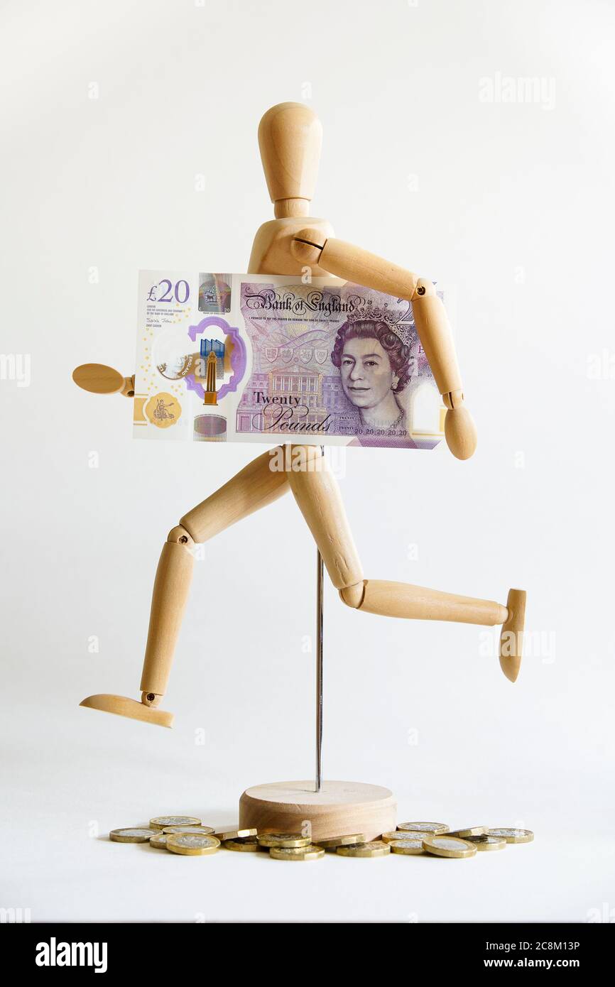 Hölzerne Schaufensterpuppe in Führungsposition, mit britischer Währung 20 Pfund Bargeld. Konzept: Nimm das Geld und renne, renne um dein Geld, mache einen Läufer. Stockfoto