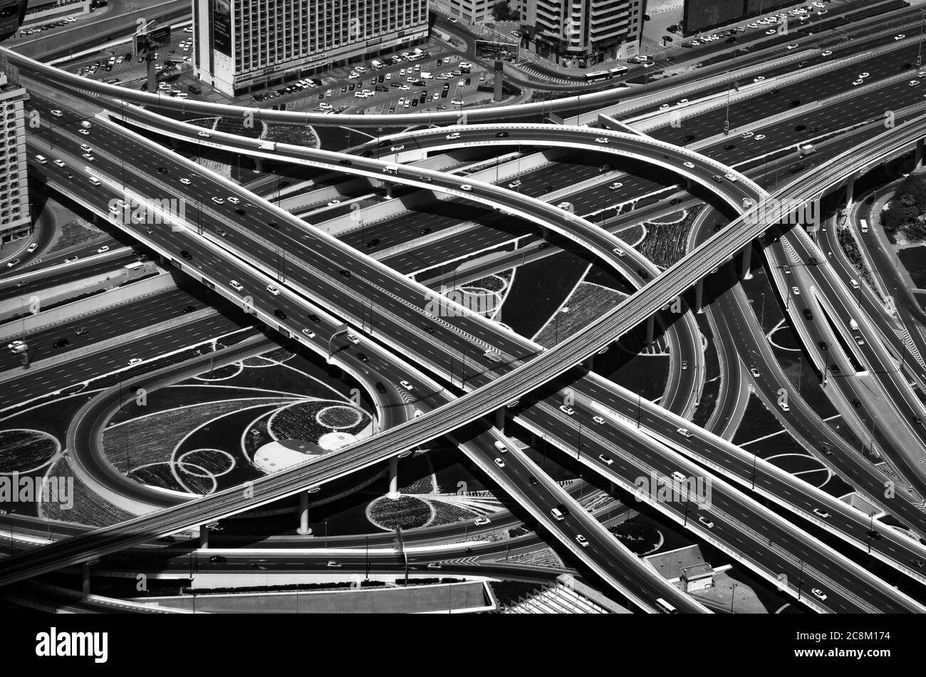 Kreuzungsstraßen von oben betrachtet. Verkehr auf der Autobahn in der Innenstadt von Dubai, VAE. Abstraktes Schwarz-Weiß-Foto mit hohem Kontrast. Stockfoto