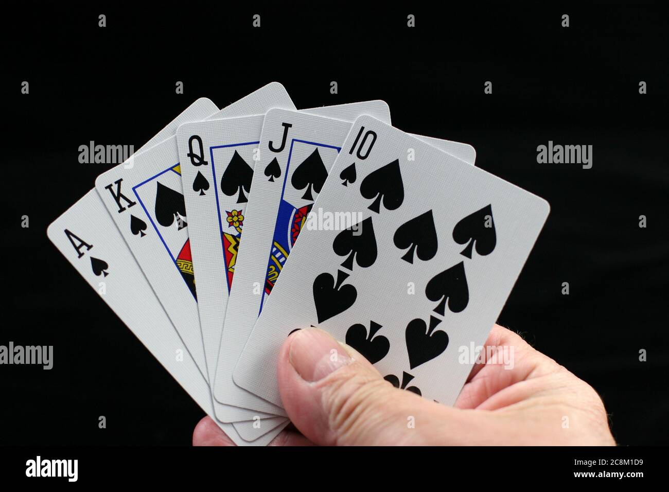 Hand hält Poker Spielkarten auf schwarzem Hintergrund. Stockfoto