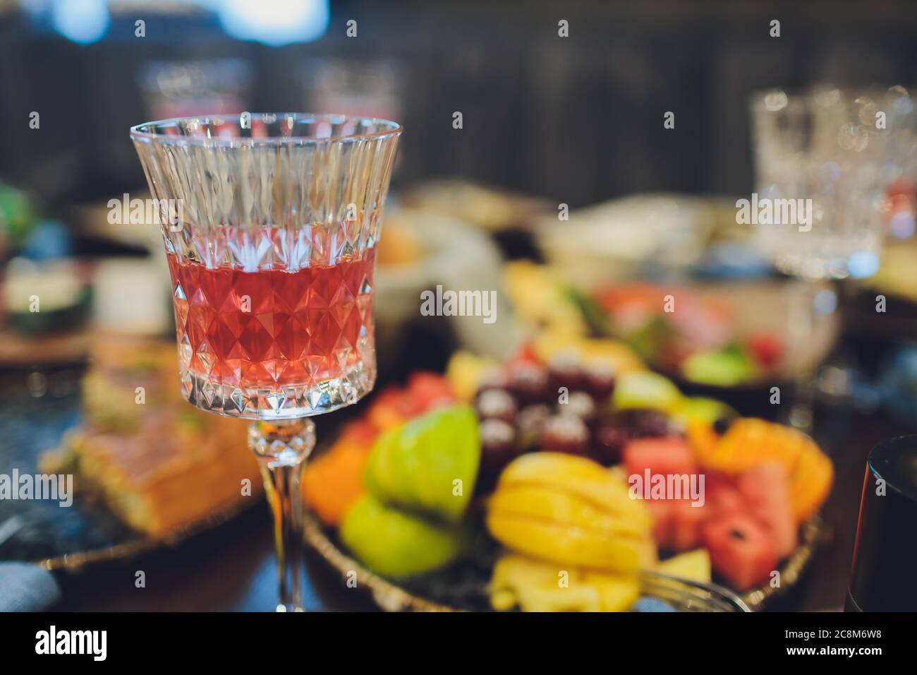 Konzentrieren Sie sich auf Hände Servieren Gerichte mit Fleisch und Gemüse an eine Gruppe von Freunden um einen Tisch auf einer Sommerterrasse versammelt. Stockfoto