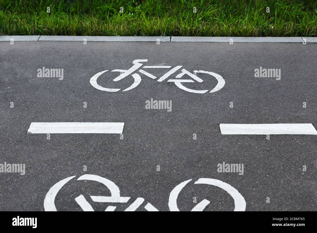 Fahrradweg Symbole auf dem Asphalt in einem Park. Fahrradschilder auf dem Fahrradweg Stockfoto