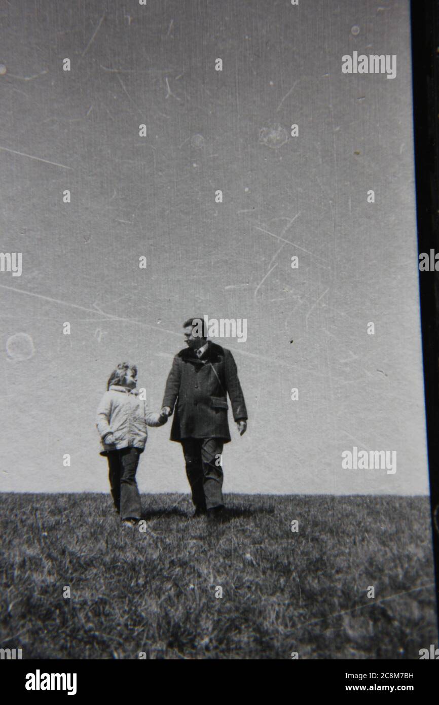Feine 70er Jahre Vintage schwarz-weiß Lifestyle Fotografie von einem Vater und Tochter herumlaufen im Park. Stockfoto