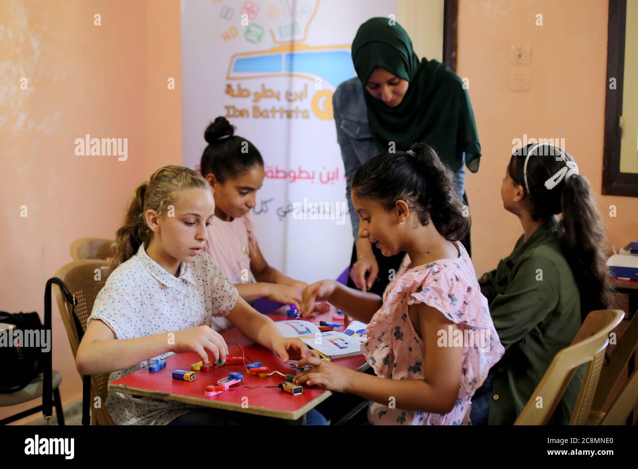 Peking, China. Juli 2020. Ein Mitglied des palästinensischen Teams "Ibn Battuta" unterrichtet Kinder im Flüchtlingslager Deir al-Balah im zentralen Gazastreifen, 25. Juli 2020. Eine Gruppe junger Menschen gründete eine Initiative "Ibn Battuta Educational", um die sogenannte non-formale Bildung zu unterstützen, eine interaktive Bildungskampagne für palästinensische Kinder in den marginalisierten Gebieten im Gazastreifen. Kredit: Rizek Abdeljawad/Xinhua/Alamy Live Nachrichten Stockfoto