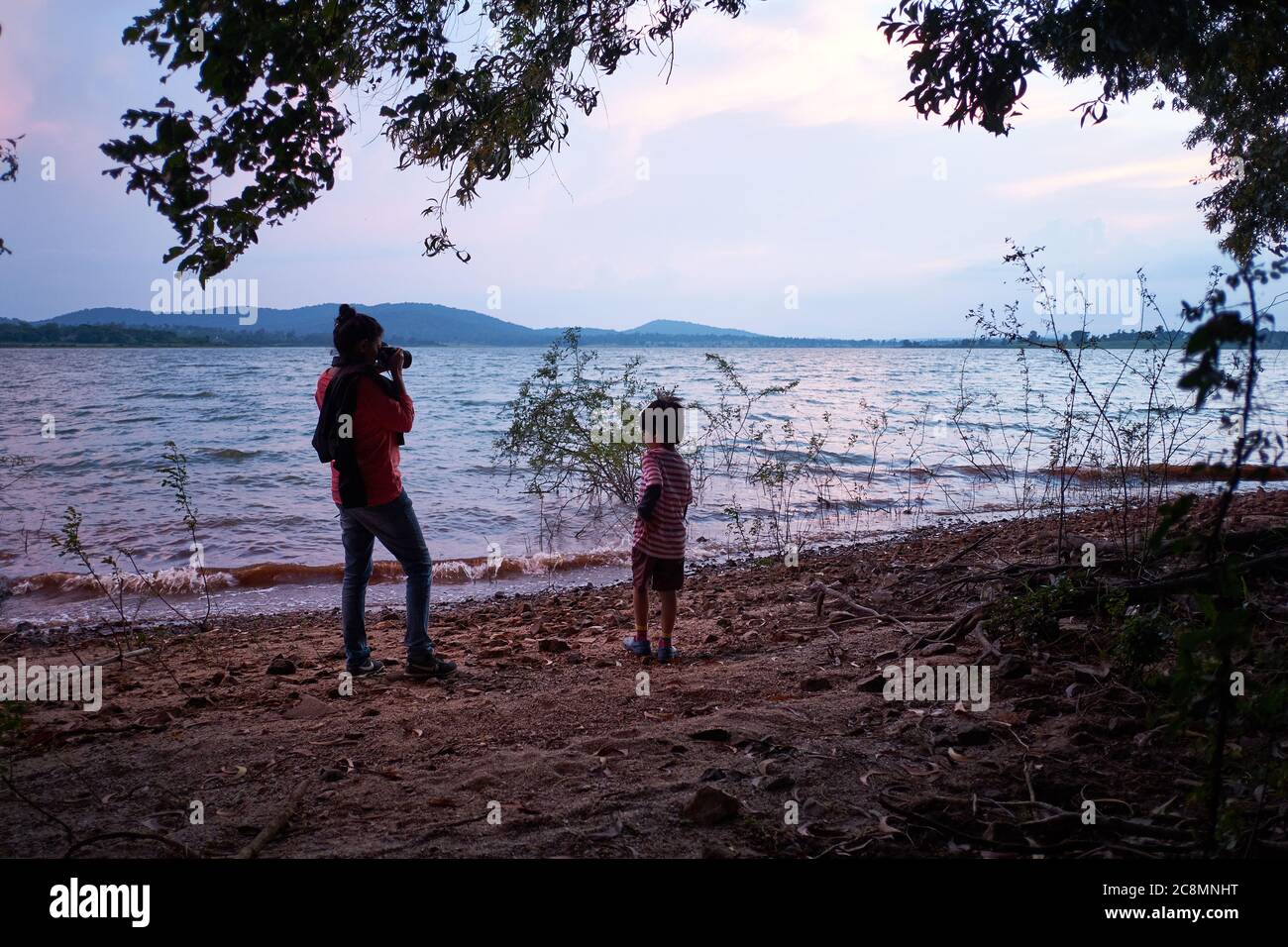 Eine junge Frau, die ein Foto eines Jungen in der Nähe des Kabini Reservoirs in Indien fotografiert. Stockfoto