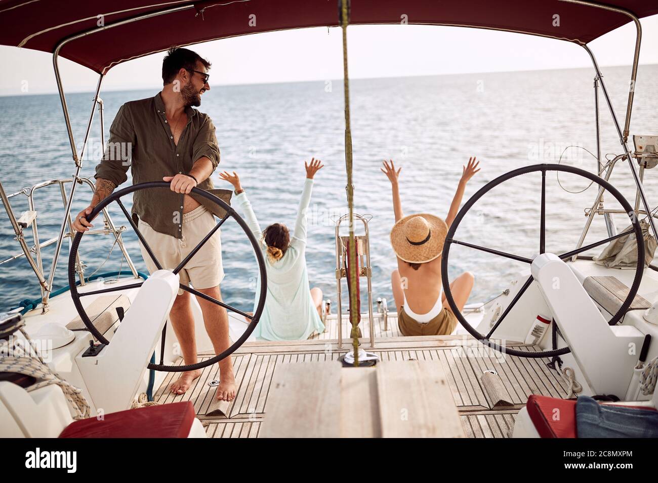 Freunde begeistert von der Reise mit einer Yacht an einem wunderschönen sonnigen Tag Stockfoto